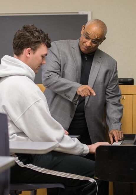 Prince Wells teaching class 01-18-17 diverse faculty A man teaching another man how to play piano.